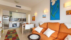 A modern living room with an orange sofa, a small round table, and a colorful rug. - Awesome apartment in San Javier (San Javier)