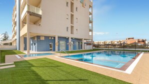 A modern apartment building with a swimming pool and a well-maintained lawn. - Awesome apartment in San Javier (San Javier)