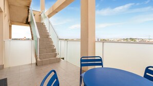 A rooftop terrace with a staircase, a table, and two chairs. - Awesome apartment in San Javier (San Javier)