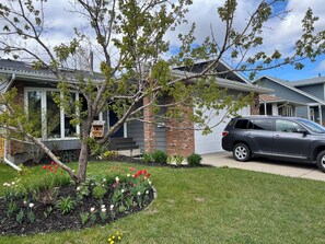 A residential house with a garage, a driveway, and a parked SUV.