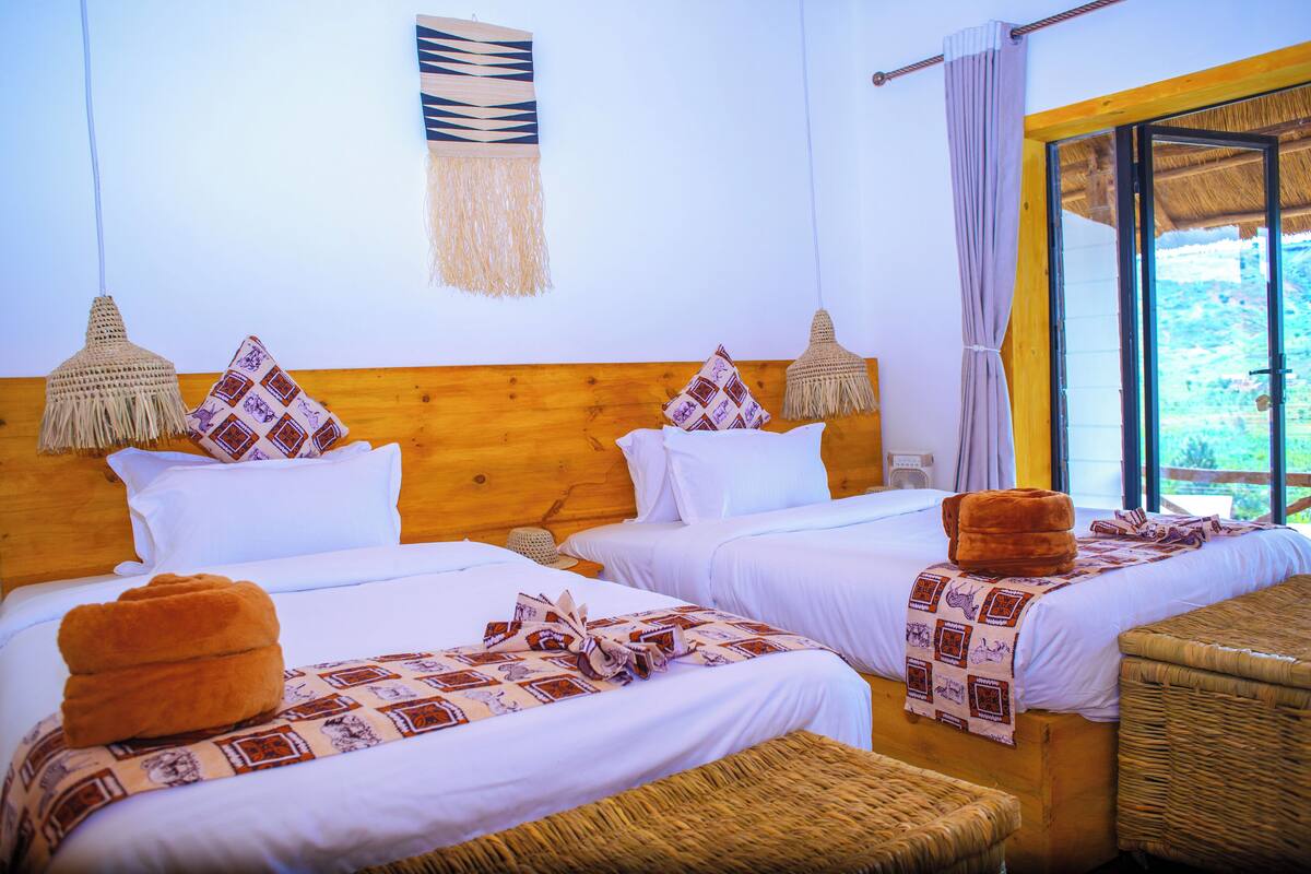 A hotel room with two beds, wooden headboards, and woven baskets.