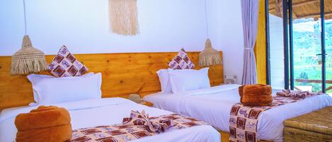 Une chambre d’hôtel avec deux lits, des têtes de lit en bois et des paniers en osier.