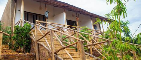Un edificio rústico con una escalera de piedra y barandillas de madera.