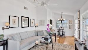 A modern living room with a sofa, coffee table, and dining area. - Ocean-View Retreat • Walk to La Jolla Cove & Village • Full Kitchen • Modern 1BR (La Jolla)