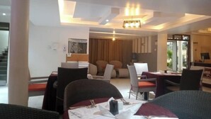Un comedor moderno con una mesa para dos personas, un sofá y vistas al exterior.