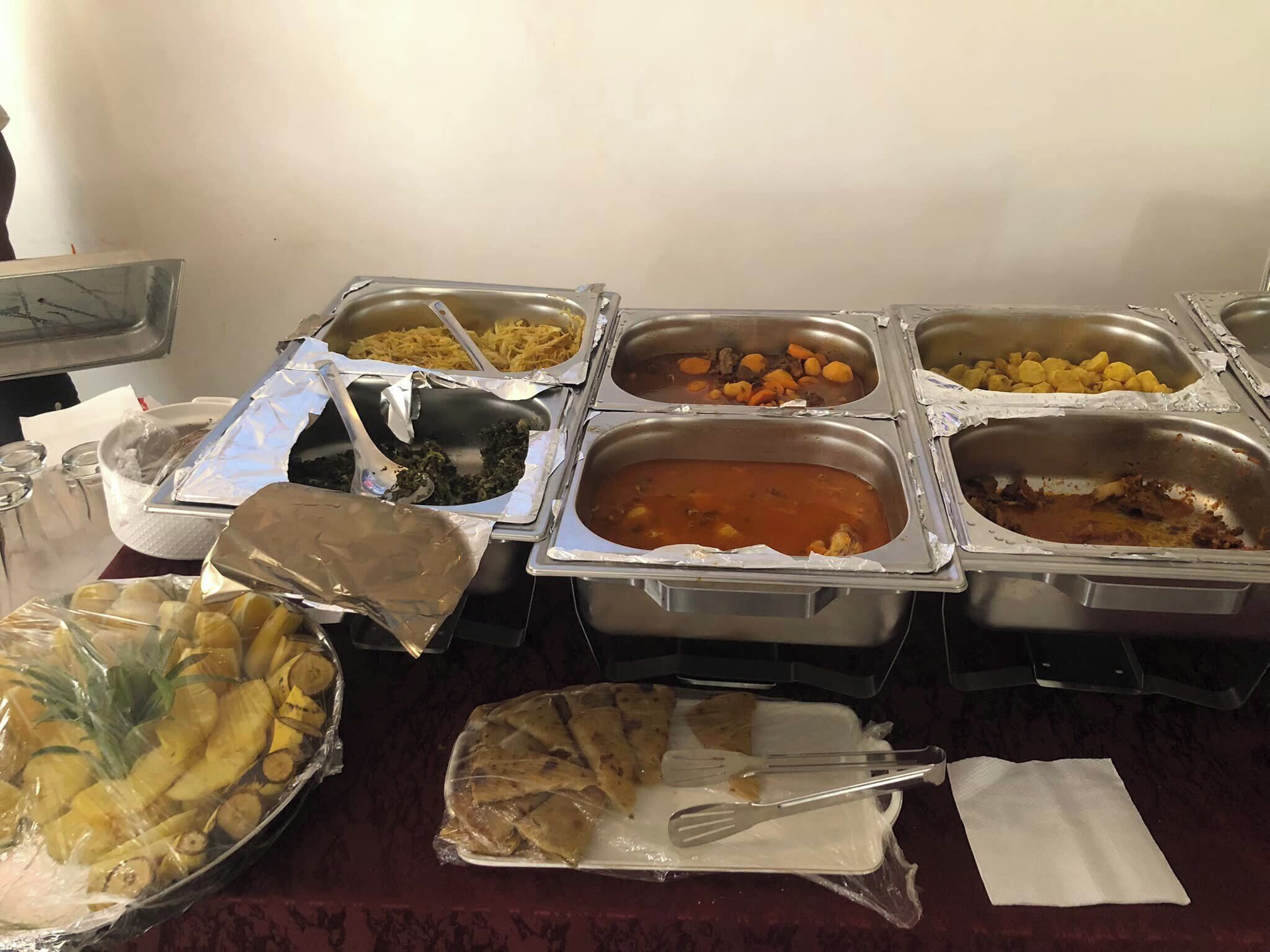 A buffet table with various food items in metal containers.