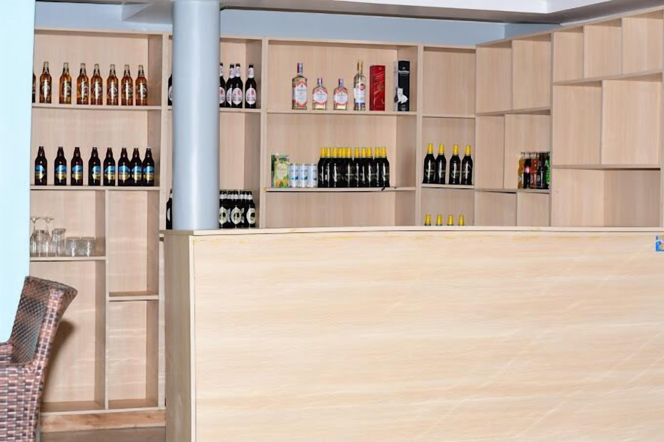 A bar area with shelves stocked with various bottles of alcohol.