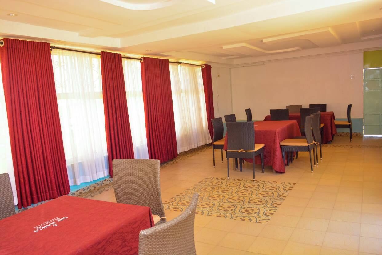 A conference room with red curtains, multiple tables, and chairs.