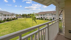A residential building with a covered porch and a well-maintained lawn.
