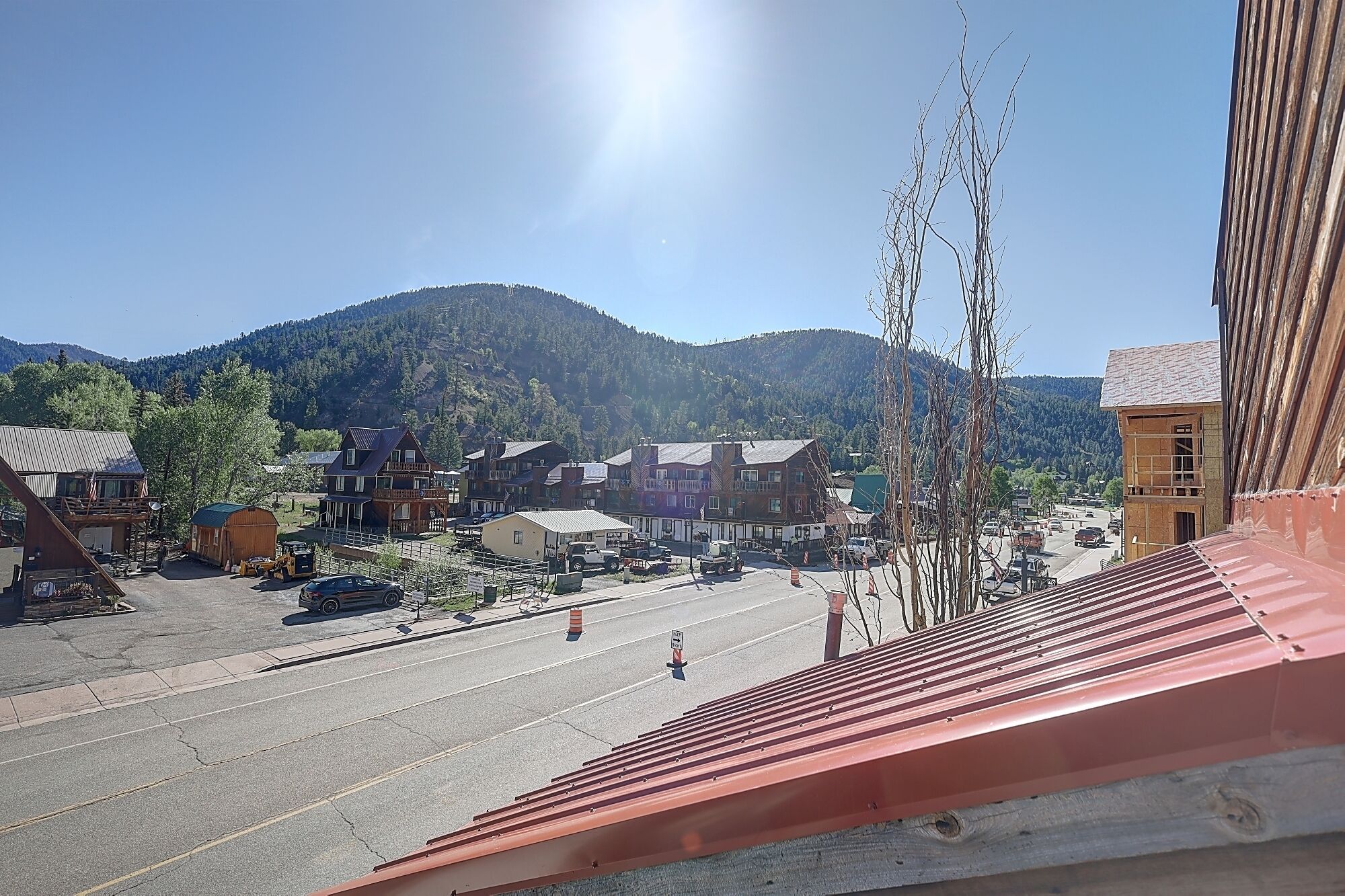 A town with buildings, a street, and mountains in the background.