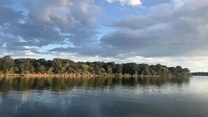 A calm lake with a forested shoreline and a partly cloudy sky. - Hubbard Shores (Breckenridge)