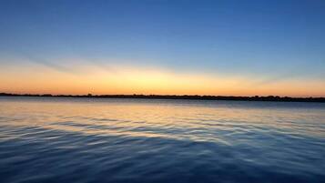 A calm body of water reflecting a sunset sky.