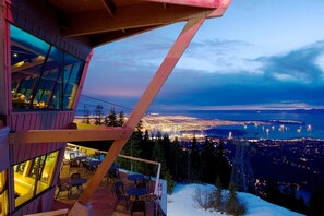 A modern building with large windows overlooking a cityscape at dusk. - Luxury Scandinavian Suite| Cozy and Bright (North Vancouver)