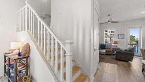 A spacious living area with a staircase, a sofa set, and a dining table.