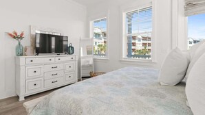 A bedroom with a bed, a dresser, a TV, and a window with blinds. - Sol Shine Gulf-View Retreat Steps from the Sand (Mexico Beach)
