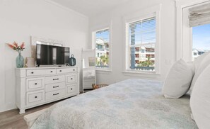 A bedroom with a bed, a dresser, a TV, and a window with blinds. - Sol Shine Gulf-View Retreat Steps from the Sand (Mexico Beach)