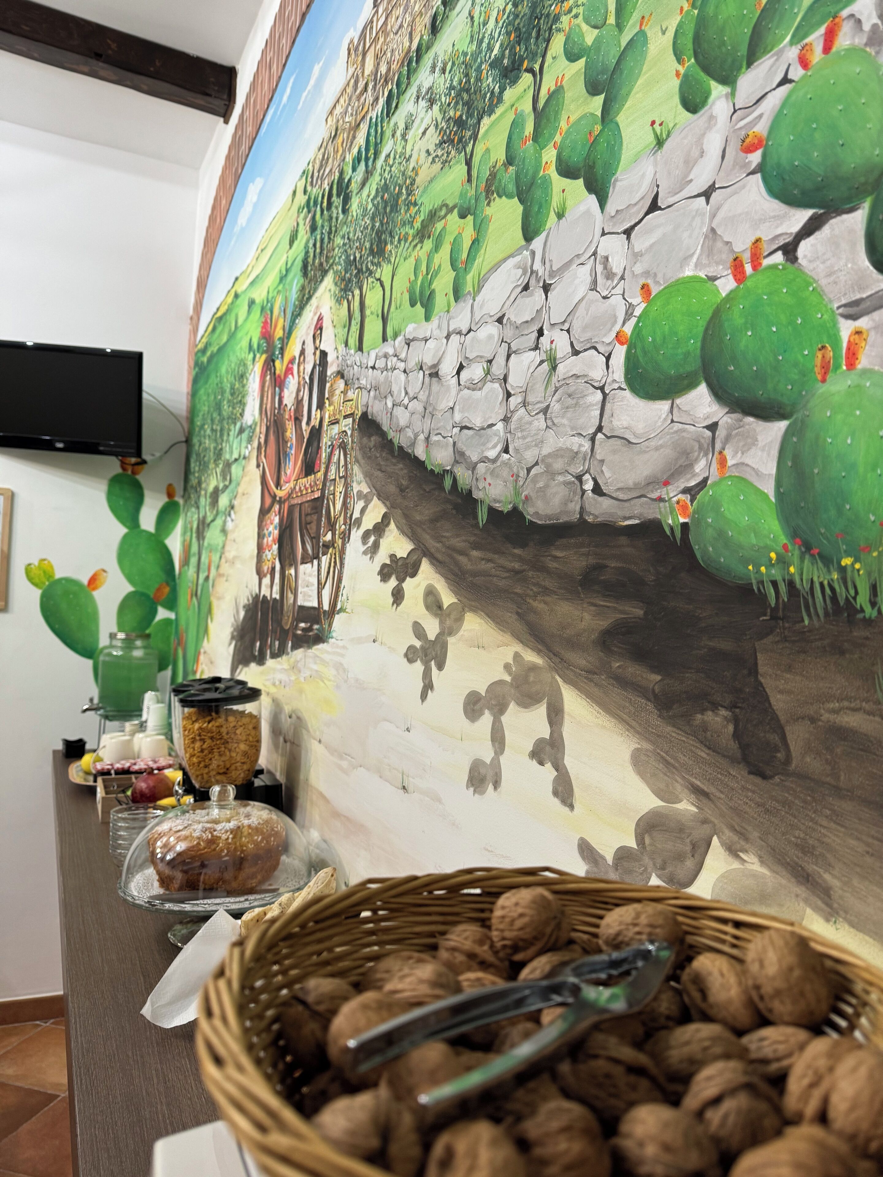 Un área de bufé con un mural de cactus y una pared de piedra.