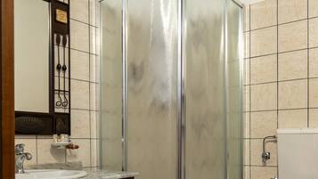 Une salle de bain avec une douche à parois de verre, un meuble-lavabo en bois et des toilettes.