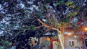 A rustic building with a tiled roof, a small porch, and a table set up outside. - Eco Sítio o Labirinto do Fauno (Belem)