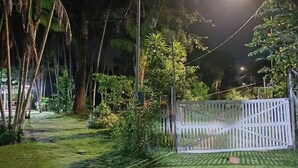 A nighttime outdoor area with a white fence, trees, and a streetlight. - Eco Sítio o Labirinto do Fauno (Belem)