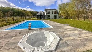 A swimming pool and hot tub on a paved deck with a house in the background. - 1 bedroom cozy apartment in Trzesacz (Trzesacz)