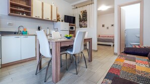 A compact living space with a kitchenette, a dining area, and a bedroom.