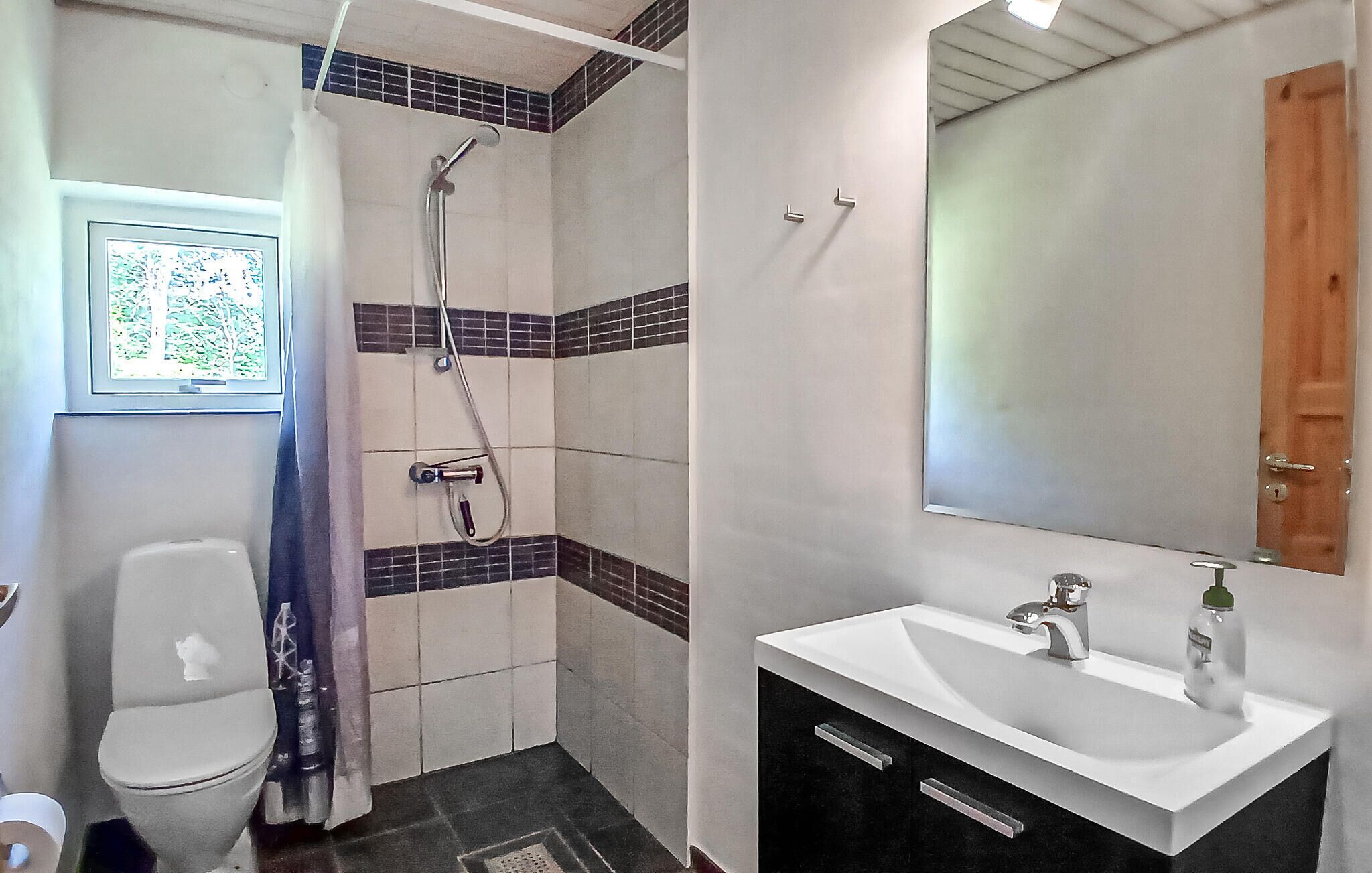 Un baño con inodoro, ducha y lavamanos.