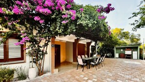 A patio area with a table and chairs, a covered seating area, and a building with a stone facade. - Cozy apartment in Pakostane with WiFi (Pakostane)