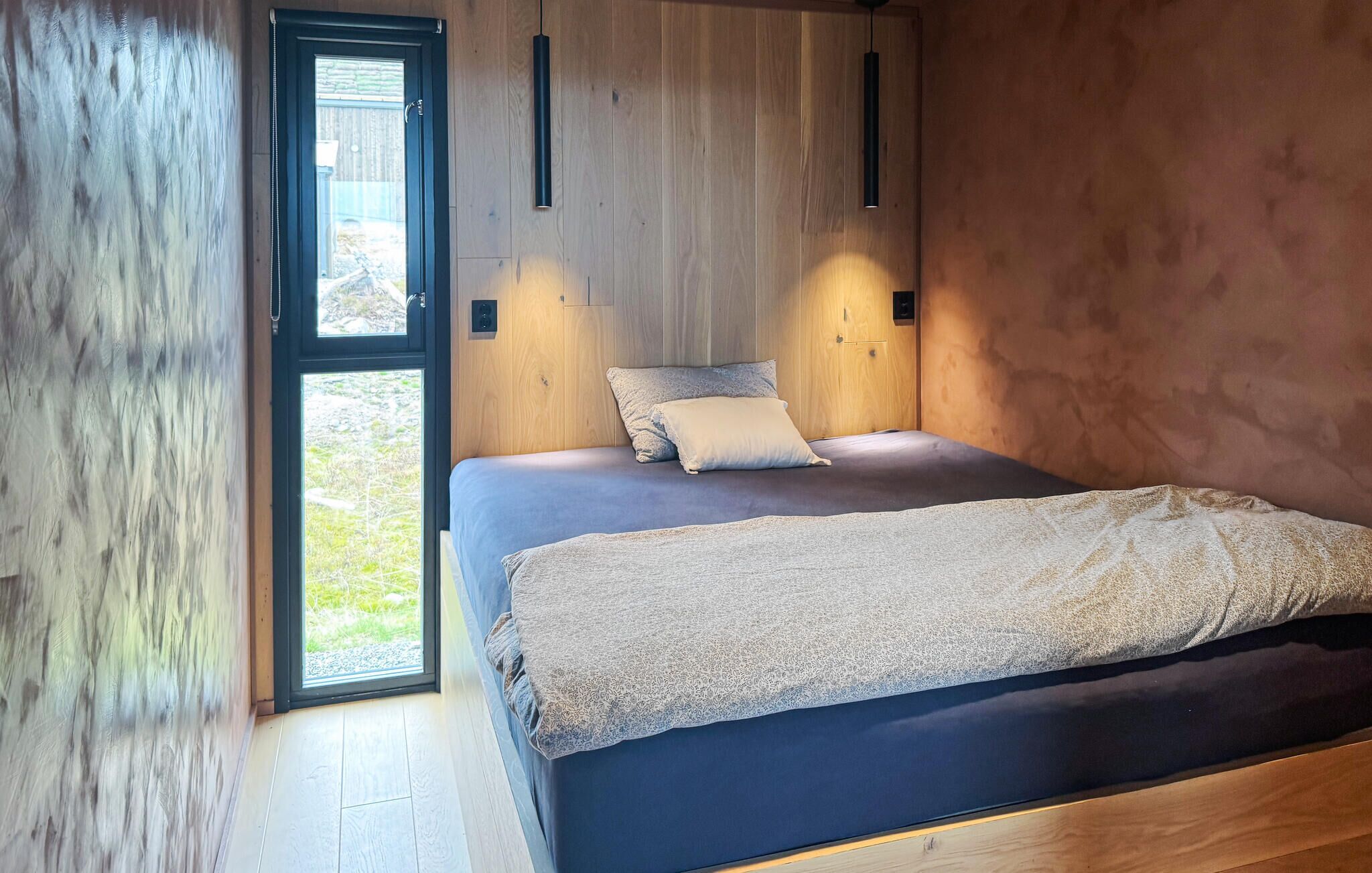A bedroom with a bed, a window, and a door.