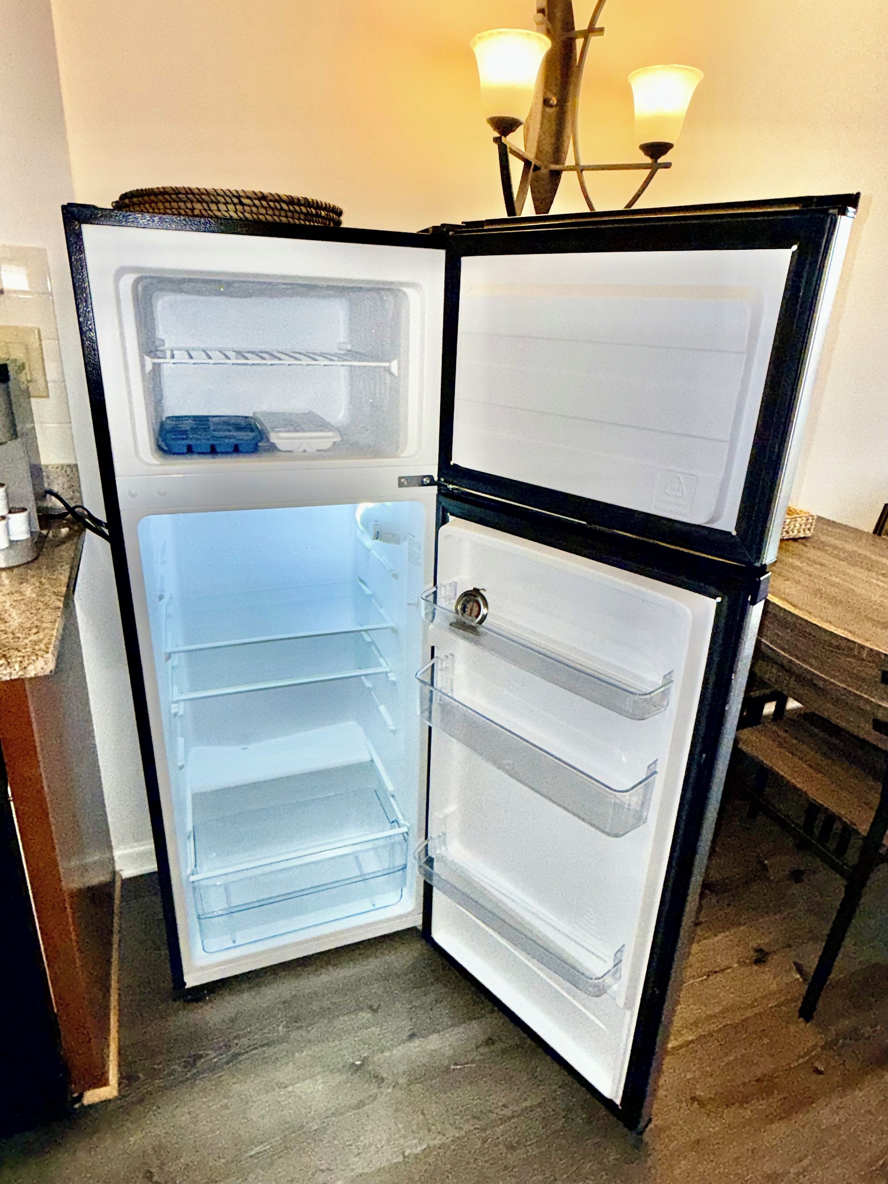 An open refrigerator with two door compartments and a freezer compartment.