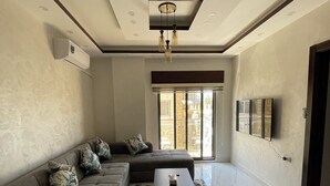 A modern living room with a sectional sofa, a coffee table, and a patterned rug.
