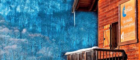 Un edificio de madera con un letrero que dice "Egoelia Les chalets de Saint Sorlin".