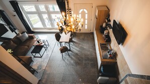 A modern kitchen with a dining area, a chandelier, and a large window. - Vacation apartment in the countryside - with lake view, terrace & barbecue fun (Lohmen)