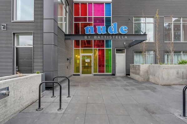 A modern building with a colorful storefront named 'nude by Battistella'.