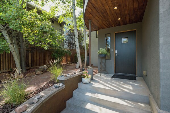 A modern house with a wooden porch, a concrete staircase, and a dark door. - Eco-Friendly - Walk to River/Mountain Trails - Near Downtown - King Beds - AC (Durango)