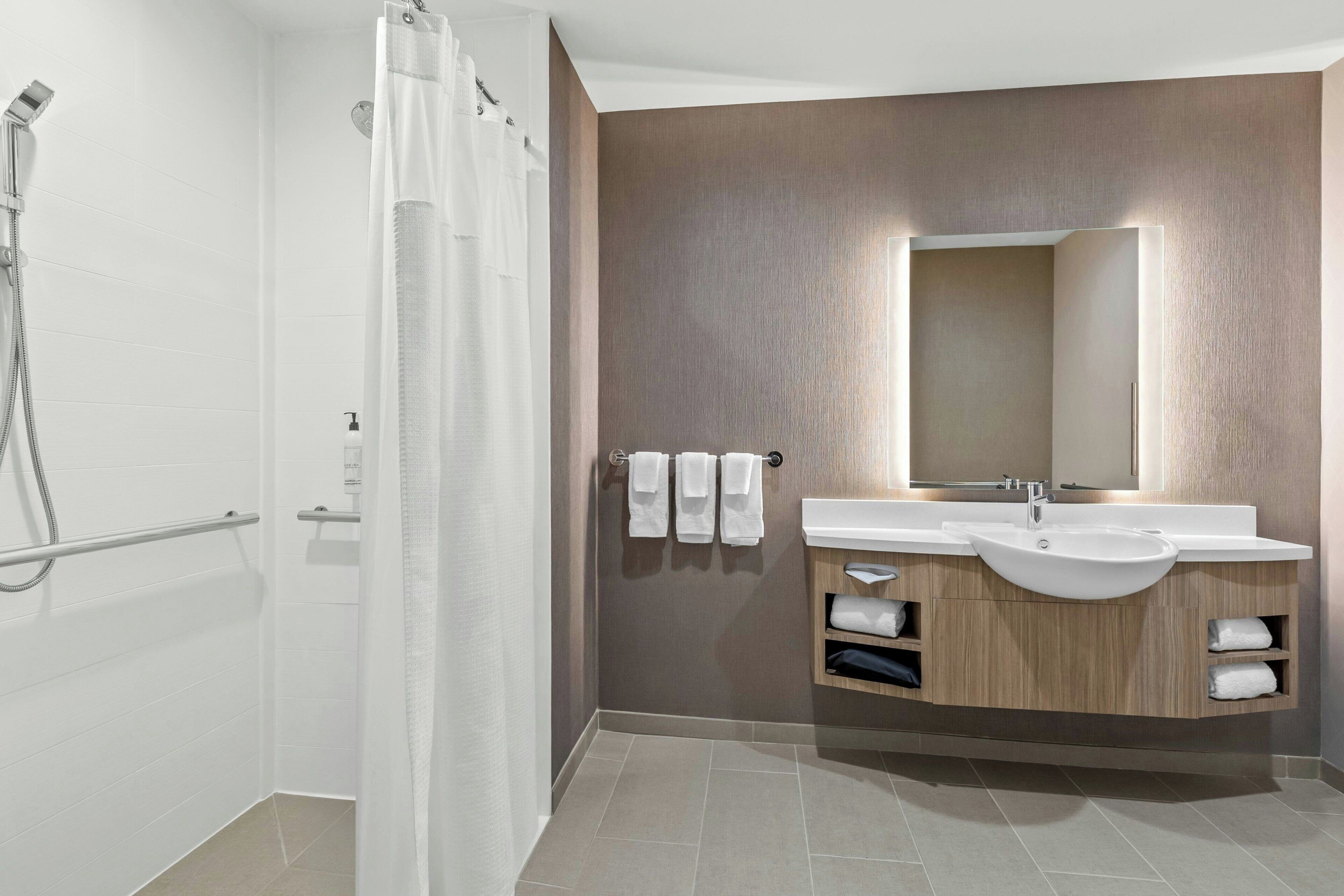 A modern bathroom with a shower, two sinks, and a mirror.