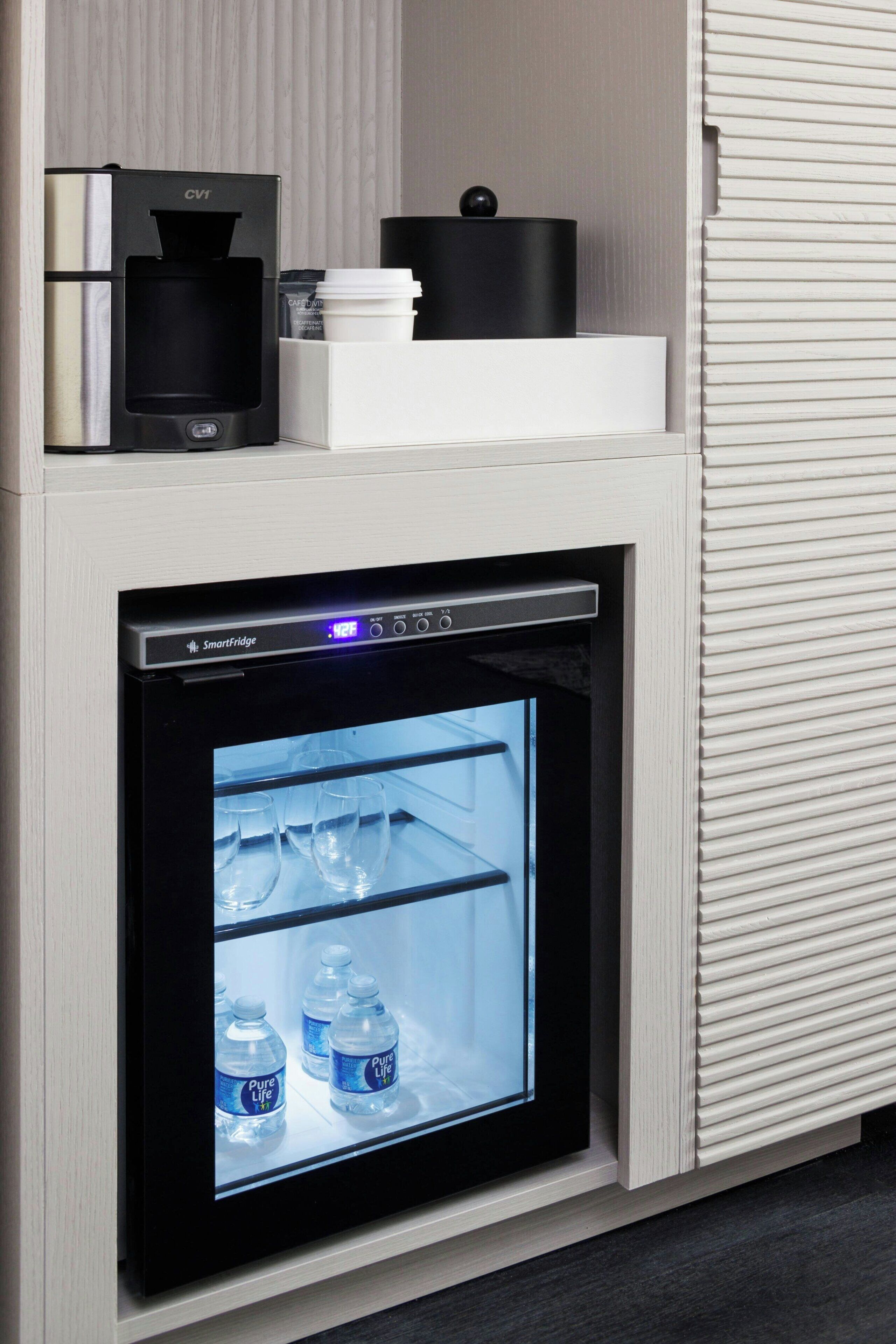 A compact refrigerator with a digital display, a coffee maker, and a water dispenser.