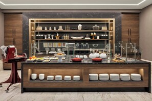 Una cocina moderna con encimera de mármol, vitrinas de vidrio y platos y cuencos ordenados.
