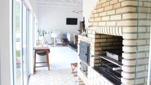Una cocina moderna con un horno de ladrillo, un comedor con sillas y un ventanal grande.