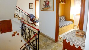 A staircase with a red railing leading to a bedroom with a bed and a nightstand. - Casa Anni `70 - Sardegna (Burgos)