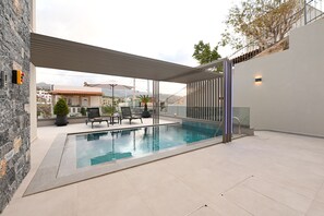 An outdoor swimming pool with a pergola, lounge chairs, and a view of the surrounding area. - MGK Complex Suite Private Pool Ground Floor (Malevizi)