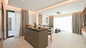 Una sala de estar moderna con una isla central, un sofá y un comedor.