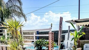 A poolside area with lounge chairs, potted plants, and a view of the pool and mountains. - Villa Lucia - Apulia (Lucera)