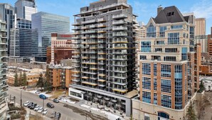 A multi-story building with a modern architectural design, featuring balconies and large windows.