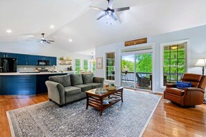 A modern kitchen with dark blue cabinets, a central island, and a ceiling fan.