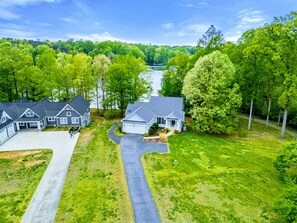 A residential area with houses, a driveway, and a river in the background. - Lakefront Lake Anna, Boat Dock, Hot Tub, Deck View (Mineral)