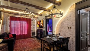 Un comedor con pared de ladrillo, candelabro y chimenea.