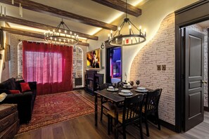 A dining area with a brick wall, a chandelier, and a fireplace.