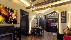 Una sala de estar moderna con chimenea, comedor y cocina con pared de ladrillo.