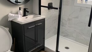 Ein modernes Badezimmer mit Toilette, Waschbecken und einer Duschkabine.